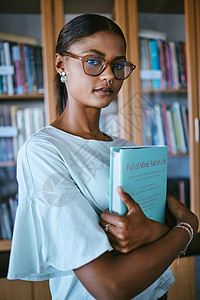 有图书馆印刷书籍的女学生从书架上拿来进行大学或大学教育和学习知识 手拿精装英文书学习或阅读的年轻女性或人背景图片