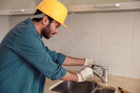 男水管工维修公司在客户厨房的水龙头修理水龙头建筑高清图片素材
