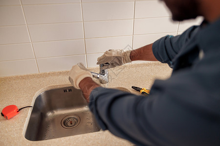 在厨房特写男性水管工修理水槽水龙头 优质的水暖公司服务安装职业成人洗手间工人机械管道建筑扳手修理工白种人高清图片素材