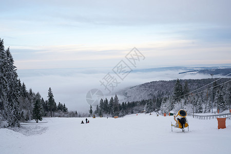 德国黑森州 Ren 的山上壮丽的冬季景观 神奇的高大苍松和雪杉覆盖着冰雪 地平线创造了一种幻觉 并与多云的天空和雾气融为一体 覆背景