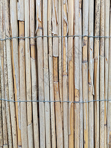 用铁丝网绑住旧的被风化的Reed栅栏高清图片