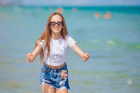 奔跑吧大逃杀沙滩上可爱的少女女孩享受暑假吧热带跑步自由童年支撑海岸海浪游泳情调孩子背景