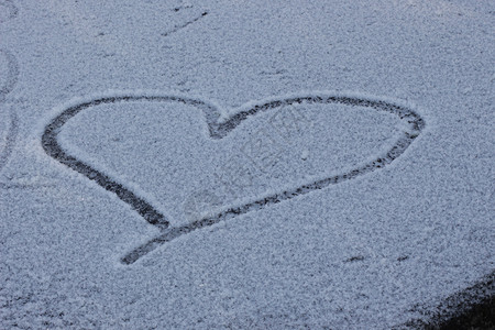 雪心心被绘制在白雪皑皑的林间空地 情人节假期装饰的背景 冰冷的心 爱 冬天的白雪 浪漫 雪中的爱情符号 文字空间背景