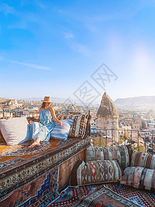 波多利亚诺穿着衣服在屋顶上衣着的年轻女子 在土耳其的景色令人惊叹女孩旅游时间沙发旅行天空裙子岩石飞机日落背景