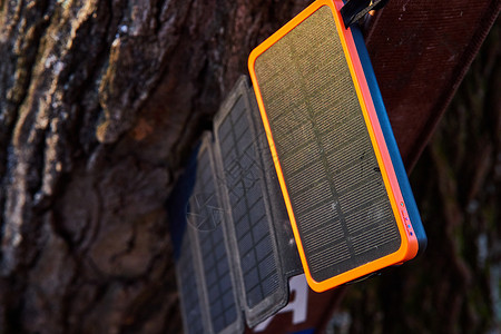 密歇根州手提式太阳能电池板用电话用树皮在阳光下充电的背景
