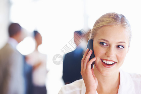 浅谈手机的商界女强人 年轻女性行政人员在手机上与业务团队交谈的特写镜头在背景中背景图片