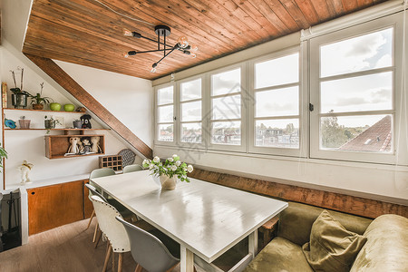 a 餐桌 椅子和窗户的餐厅公寓桌子沙发建筑学天花板风格家具玻璃木头地板图片