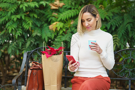 搜索花边素材女性在花边的长凳上浏览智能手机背景