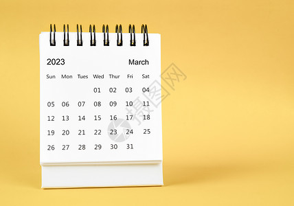 2023年3月黄色背景的案头日历背景图片
