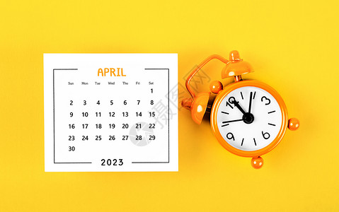2023年的月历 黄色背景有闹钟 在2023年4月背景图片