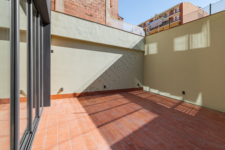 房间玻璃门由黑色金属和玻璃制成的红色地板瓷砖和滑动门 在巴塞罗那现代住宅楼内建造背景