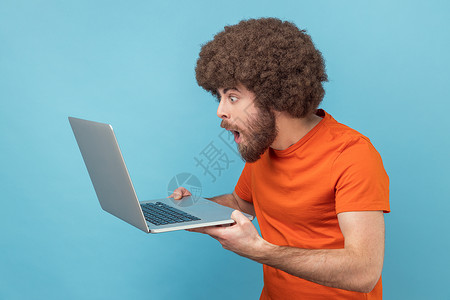 编程爆炸素材在笔记本电脑上做自由职业的人 在互联网上打字 看着笔记本电脑屏幕感到惊讶背景