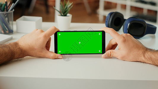 年轻成人分析智能手机上横向绿屏显示的青年分析背景