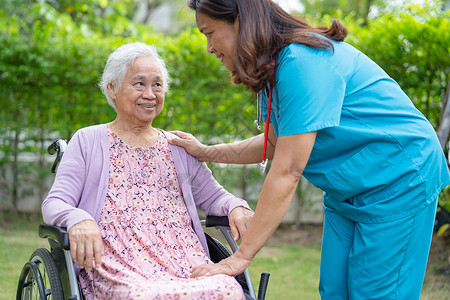 摩擦起电护理医院公园轮椅上的医生护理人员帮助和护理亚洲老年或老年老妇人患者 健康强健的医疗理念机动性照顾者微笑医院女士病人挑战疾病女性摩背景