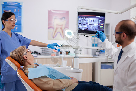 向高龄妇女解释诊断的口腔病理学射线药品扫描牙科考试阅读成人放射科x光诊所背景图片