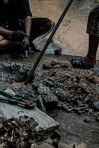 水电工人使用工具 在下雨时修补商业建筑供水的破损水管主干线背景