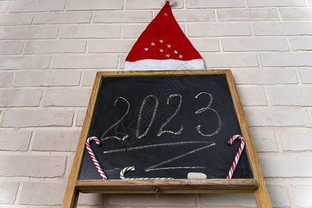 2023年以粉笔写成的黑板 新年快乐数字广告牌问候语日记教育手杖假期商业焦糖学校背景图片