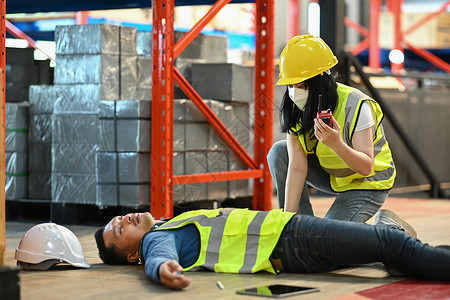 仓库工人意外后在地板上昏迷不醒 同事呼救或报告工作事故时由对讲机作随叫随到背景图片