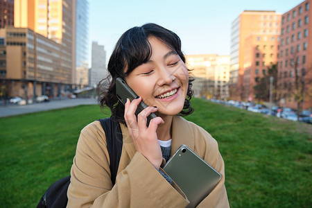 大学生活方式 年轻亚洲学生 有平板和笔记本的女孩在街上走出校园走出去时用移动电话讲课电话界面手机技术艺术互联网细胞艺术家笔记用户背景图片