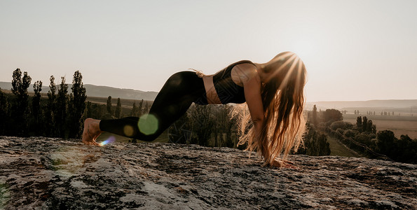 绑腿健身女人 漂亮的中年妇女留着长头发 穿着紧身裤和上衣的健身教练在森林附近的岩石上做伸展运动和普拉提 女性健身瑜伽常规概念日落女孩背景