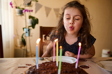 美丽的小生日女孩 在节日巧克力蛋糕上吹蜡烛 庆祝她在家5周年的庆典活动五周年背景