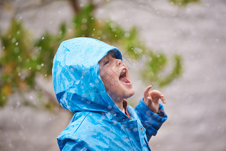 尝着雨的滋味 一个小男孩在外面玩背景图片