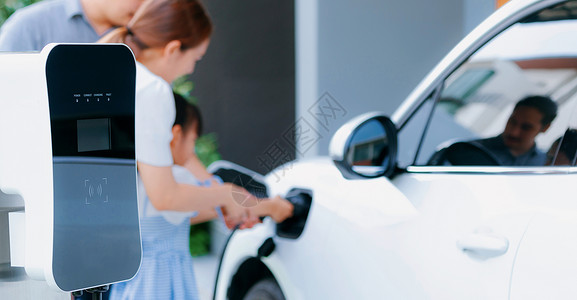 在 ho 的 EV 车上插入递进 EV充电器插件爸爸母亲充电器生态电动车收费家庭妈妈电池技术背景图片