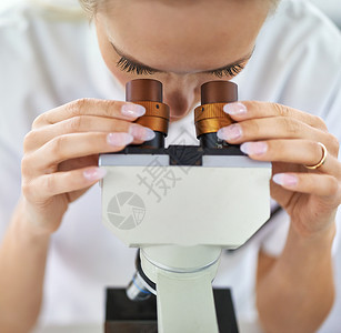 集中在治愈方法上 一个在实验室用显微镜工作的漂亮女人 她是个美人背景图片