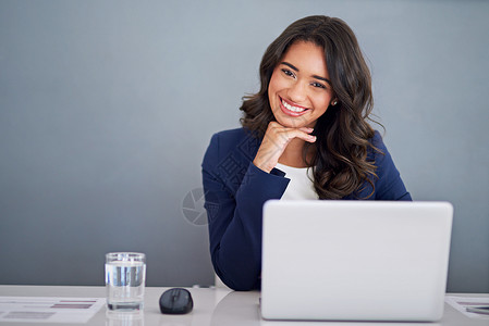 成功要归功于那些为它工作的人 一个年轻商务人士在她的笔记本电脑上工作的肖像背景