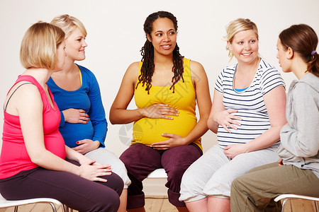 讨论他们的希望和梦想 一群孕妇坐在一起分享她们的感受背景