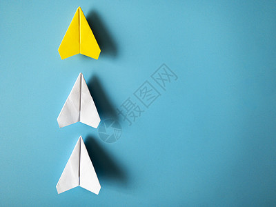 黄色折纸箭头黄纸飞机折纸式主要白色飞机 蓝背景 有可定制的文字空间 领导才能概念 (掌上型)背景