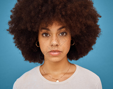 妇女头像蓝色工作室背景下的黑人女性 天然头发和爆炸头 用于护肤 护发和美容 为美容 时尚和自我保健动机摆姿势的非洲模特的面部肖像或头像背景