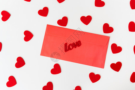 一封情书 在小红心背景下的红纸信封上写着爱的铭文 情人节的概念背景图片