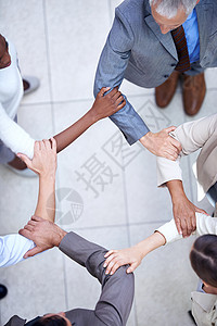 生意上联合起来 一群商业同事手握手臂站着背景图片