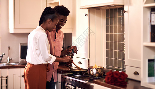 一对可爱的年轻夫妇在家情人节一起做饭 简直是太好啦! - 对啊!背景图片
