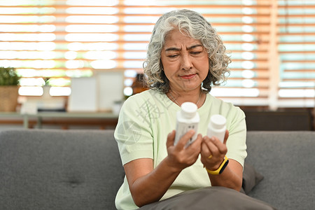 成年女性在吃药前阅读有关包装的医学教育 老年人保健 医药概念 15背景图片