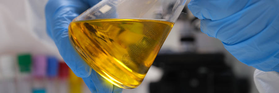实验室净化手套内化学化学家持有含有黄油液的测试管 供研究封闭食物教育添加剂科学家实验室创新制造商润滑矿物管子背景