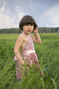 小女孩站在草原的草地上 夏天背景图片