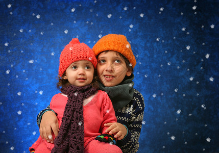 哥哥姐姐在冬天玩得开心 责成 微笑 滚雪球 圣诞节 毛衣背景图片