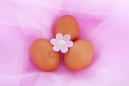 粉红色织物上的复活节鸡蛋背景图片