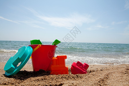 海滩上多彩塑料玩具 晴天 齿轮 阳光 孩子背景图片