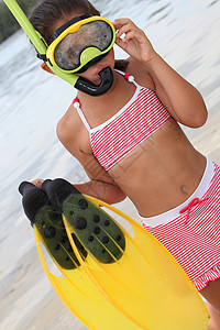 标潜水装置海滩上的小女孩穿着泳衣 还有潜水装置 穿泳衣和潜水器背景