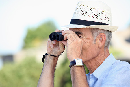 人脸老化素材老人透过望远镜看望着背景