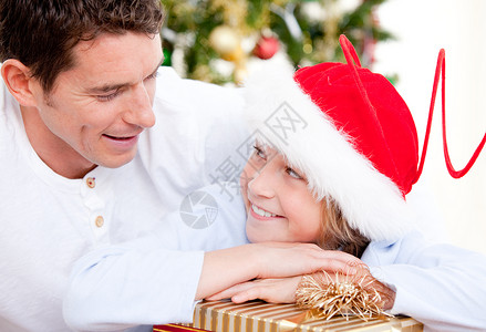 圣诞老人发礼物迷人的父亲与儿子一起庆祝圣诞节的喜悦父亲背景
