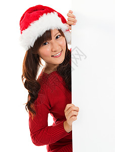 圣诞女孩从空标牌广告牌后面偷看背景图片