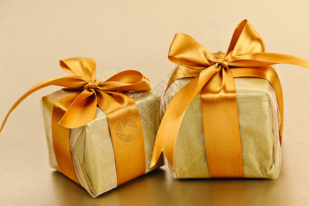 两个金包金礼品盒 弓 盒子 庆典 包装 圣诞节 惊喜背景图片