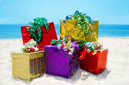 海滩上的礼品箱和袋袋   假日概念背景图片