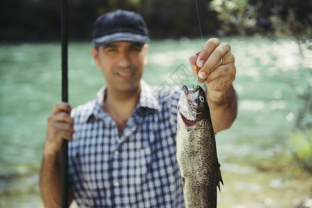 鳟鱼米勒在河上钓鱼 把鱼看镜头 帽子 男人 自然 水 溪流背景