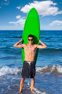 少年冲浪员在海滩上架着冲浪板 前滩 微笑背景图片