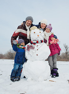 家庭做雪人 乐趣 圣诞节 父亲 建造 滚雪球 胡萝卜 帽子 男生背景图片
